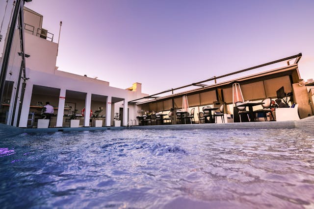 ein Pool mit Tischen und Stühlen im Hintergrund